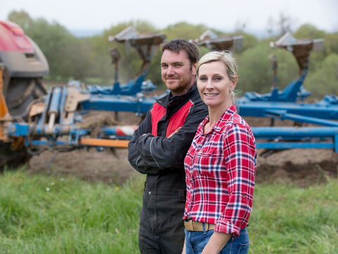 Ein Landwirt und eine Landwirtin blicken positiv in die Zukunft