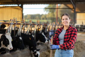 Portrait of positive woman farmer in cowshed Portrait of positive woman farmer in cowshed