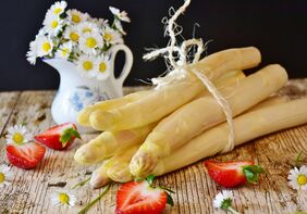 Ein Bund Spargel und halbierte Erdbeeren